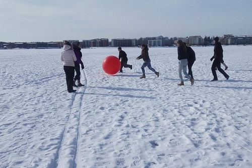 nuoret pelaavat jäällä isolla pallolla