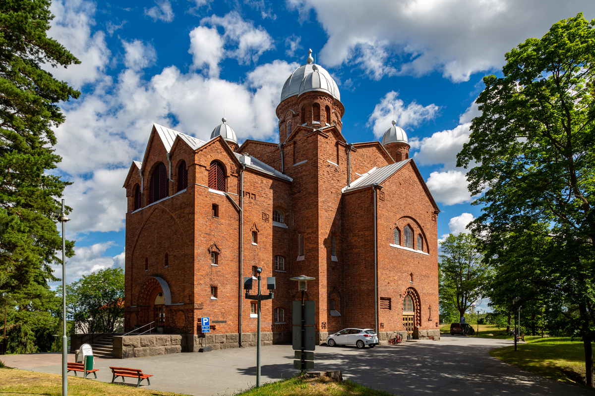 Lappeenrannan kirkko kesällä vehreiden puiden ympäröimänä.