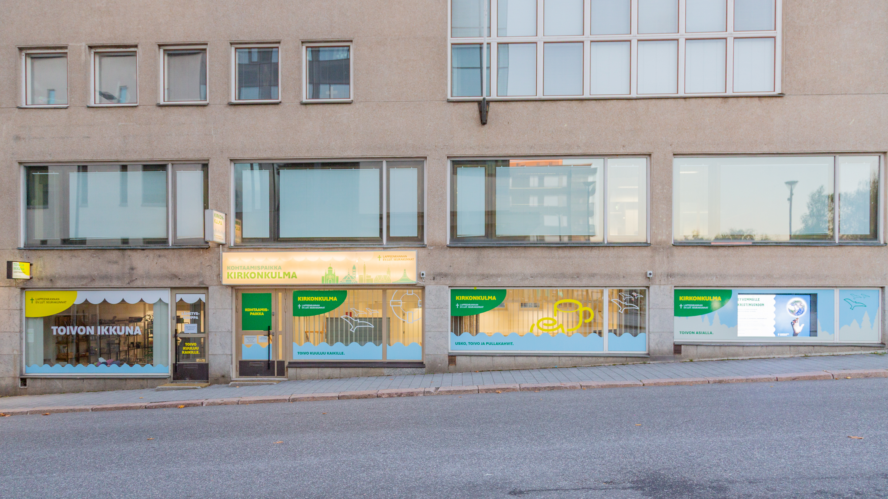 Kirkonkulma, Kirkkokatu 10 rakennus. Suurissa ikkunoissa värikkäät teippaukset. 