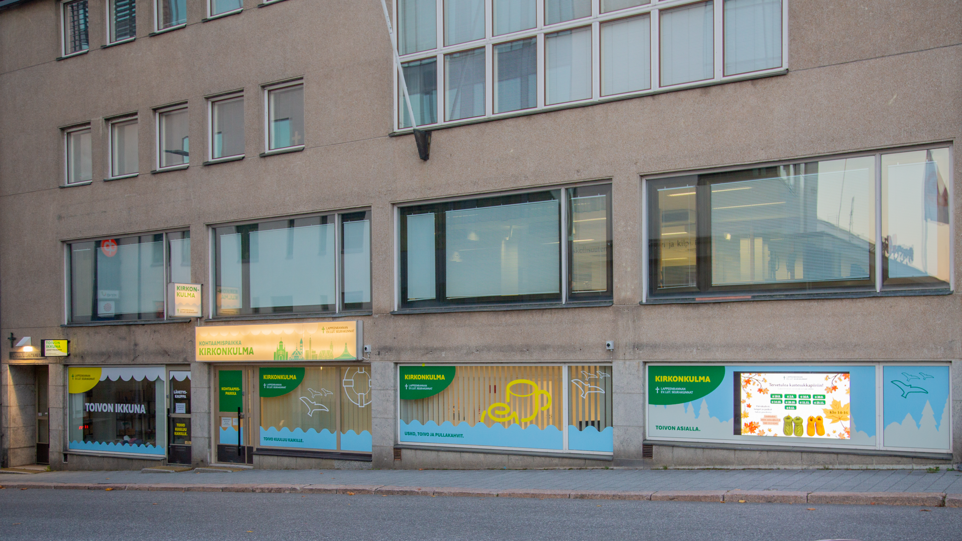 Kirkonkulma, Kirkkokatu 10 rakennus. Suurissa ikkunoissa värikkäät teippaukset.