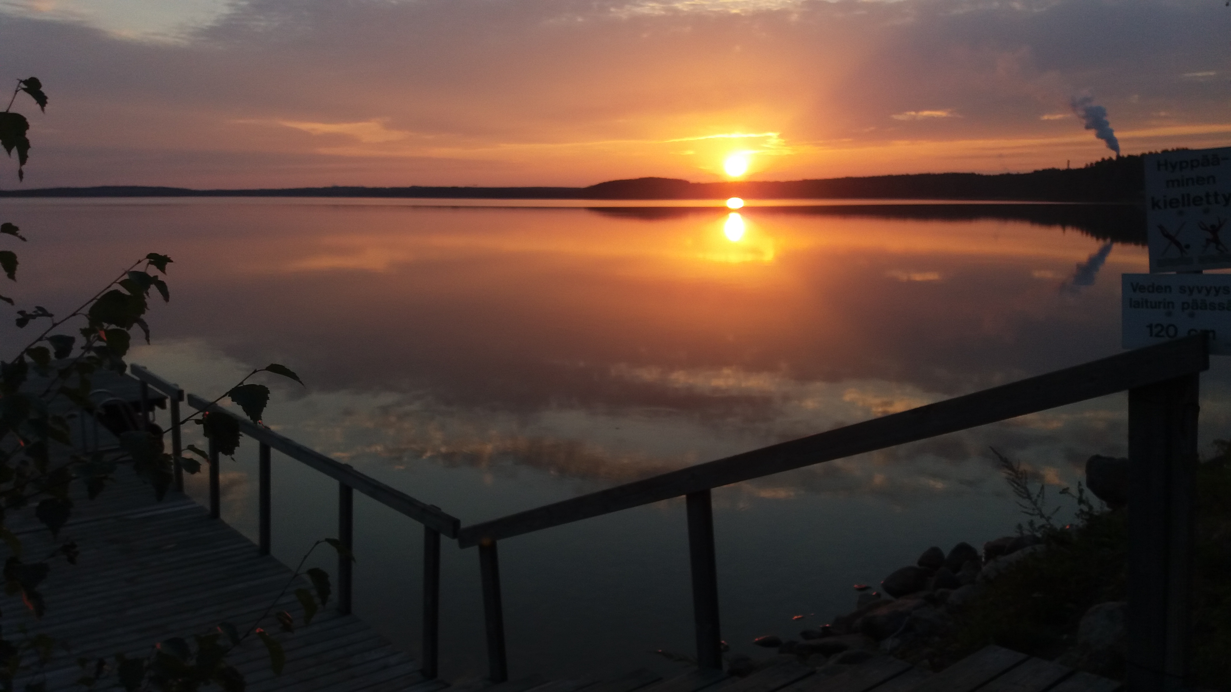 Kuvassa auringonlasku järven rannalta. Kuva on otettu kesällä 2018 kuurojen saunaillassa Imatran Päivärannassa