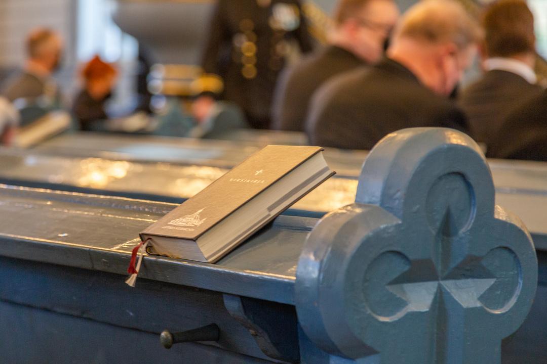 A hymn book on a church pew during a worship service