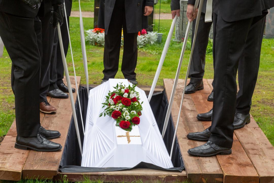 Volunteers lowering the coffin