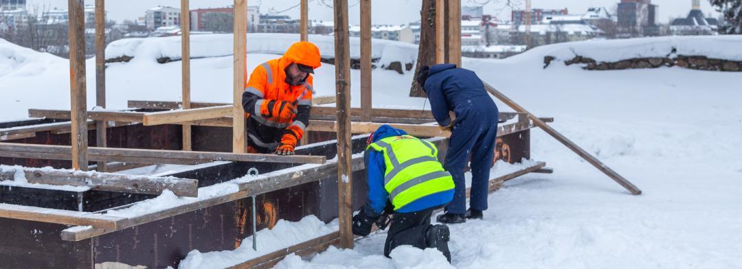 Three men building a snow church